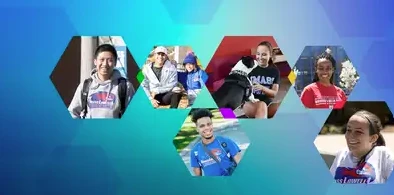 Multiple people smiling, wearing shirts with a school's logo.